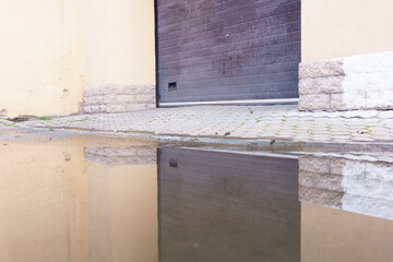 Reflection of a garage door in a puddle of water