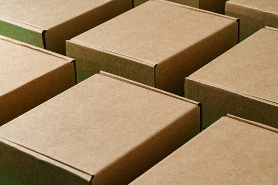 A close view of multiple brown cardboard boxes stacked closely in a warehouse