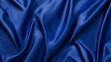 Fototapeta premium A close-up of smooth blue satin fabric, showcasing elegant folds and sheen. Perfect for textures, backgrounds, and fashion-related projects.