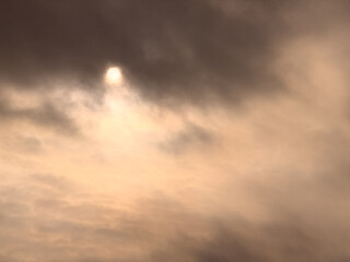 A cloudy sky with a sun shining through it