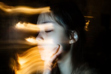 Fototapeta premium Woman with Eyes Closed Surrounded by Golden Light Streaks