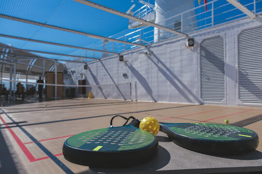 Two paddle tennis rackets with field court onboard luxury ocean liner cruiseship cruise ship on outdoor deck