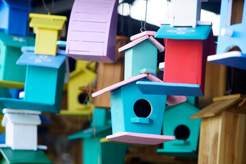 Colorful Wooden Birdhouses Hanging in a Market Display, Showcasing Unique Designs and Vibrant Colors for Nature Lovers and Garden Decor Enthusiasts