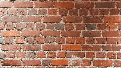 Close-up view of a red brick wall with natural textures and slight imperfections, showcasing classic masonry
