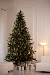 Fototapeta premium A large Christmas tree with lights and ornaments sits in a white room