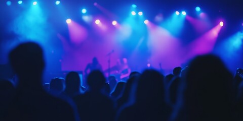 Musical concert in a vibrant nightlife setting, featuring professional blue and purple light projectors that illuminate the silhouettes of concert goers. This blurred photo captures the lively