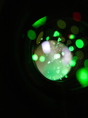 Abstract green bokeh lights reflected through a camera lens
