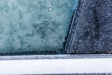 Close up of frost on frozen car window on cold freezing winter day.