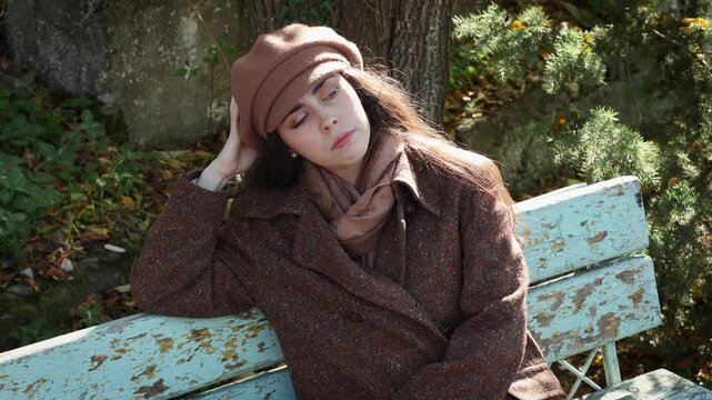 Top view of caucasian young thoughtful woman, with an apathetic look sitting on bench. Negative emotions of sadness and depression. The concept of psychology and mental health