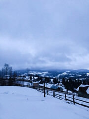 Peaceful winter landscape with snow-covered village and hills