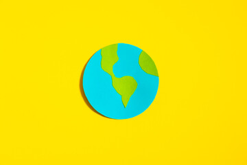 Earth planet made of paper on yellow isolated background, Earth planet concept