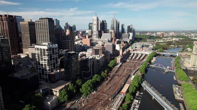Beautiful high aerial of Melbourne skyline. Downtown Central Business District, Flinders Street Railway Station and Yarra River, clean 4K drone shot