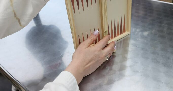 Closeup of hands setting up game of backgammon and chess on table