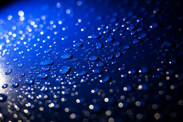 A vibrant blue background adorned with an abundance of water drops