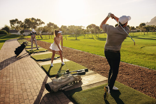 Golf group enjoying driving practice and friendly competition at driving range