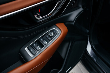 Naklejka premium Modern brown car interior, leather steering wheel, climate control, large navigation screen, air ducts, deflectors on the car panel. Interior details.