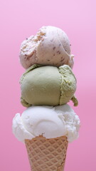 Delicious ice cream cones featuring vanilla, green tea, and nut flavors against pink background.