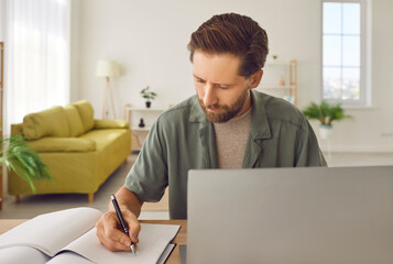 Man working, studying at home with laptop from remote location, comfortable productive arrangement,...