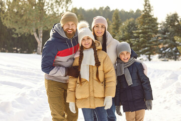 Happy smiling family, winter snowy outdoor portrait spending Christmas holiday wearing warm outfit, children, smiling parents, excited in affection, enjoy New Year weekend activity walking in forest