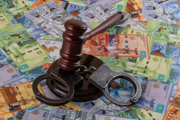 Handcuffs and bills of different denominations of the Kazakh currency tenge