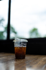 After drinking iced coffee in a transparent plastic cup on wooden table