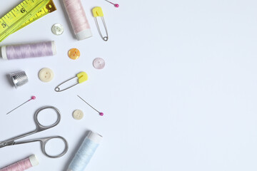 Flat lay composition with different sewing supplies on white background