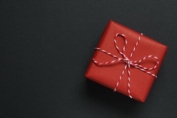Beautiful gift box tied with bow on black background 