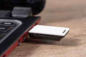 White usb flash drive connected to laptop on table.