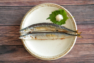 Two salt-grilled sauries, the most important autumn food for Japanese people, are served on a...