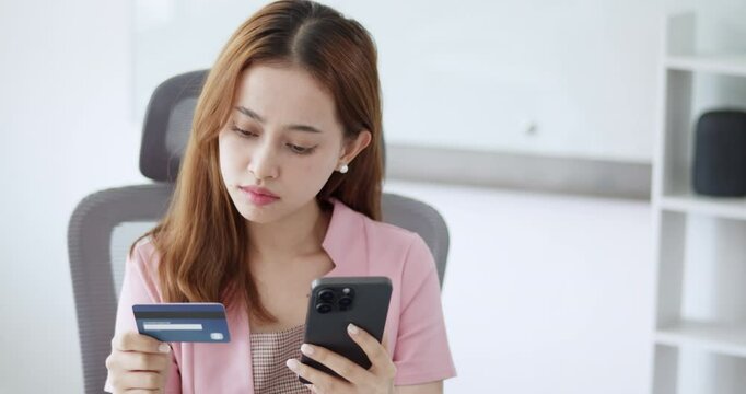 A young office woman encounters an issue with her credit card during an online transaction, calling the bank to resolve the problem and safeguard against fraud.