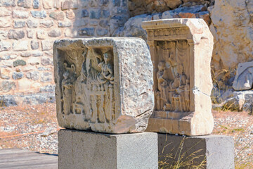 Ancient stone steles with intricate carvings, showcasing historical reliefs, displayed outdoors...