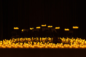 blurred symphonic orchestra on stage with lots of candles
