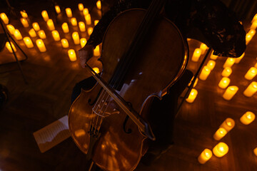 closeup of cello with lots of candles