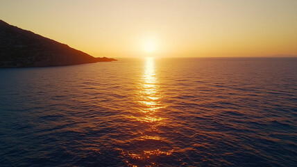 Obraz premium Golden sunset over calm sea with warm glow reflecting on water, creating serene and peaceful atmosphere