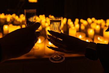 wine glasses on the background of symphonic orchestra on stage with lots of candles