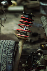 a mechanic disassembles an old dirty car engine on a red lift for repair and tuning