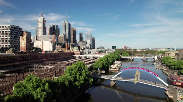 Prince's Bridge with Merry Christmas sign, Melbourne skyline in background, 4K drone shot