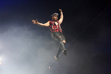 Circus show with tightrope walkers under dome of the circus under the light of spotlights and smoke. © Studio Peace