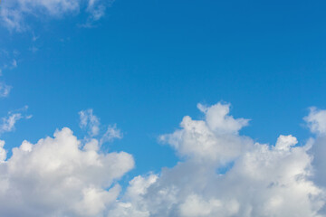 Bright blue sky with scattered white clouds, creating a calm and open atmosphere, ideal for backgrounds, nature, and weather themes