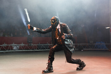 A circus show with knife throwing in the circus arena. The man in the mask dreams of knives.