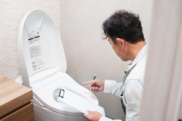 トイレの点検をする水道工事業者 © polkadot