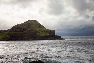 Rocky Coastline in Ireland with Green Grass and Dramatic Clouds