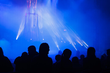 Circus equipment with colorful spotlights. Rays of light in the circus arena. Silhouettes of people