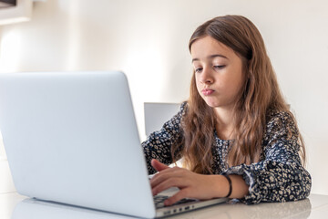 A sad girl is working on a laptop. Sad girl and laptop. Technology concept.