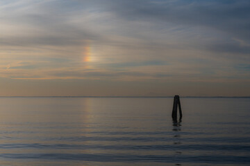 Fototapeta premium Lo spettacolo meraviglioso delle nuvole iridescenti sopra il mare davanti all’isola di Pellestrina poco prima del tramonto