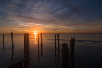 Obraz premium L’ultimo raggio di sole pone fine a un bellissimo tramonto sul mare all’isola di Pellestrina