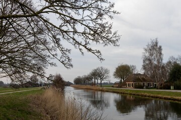 Scenic rural landscape with canal and farmhouse.