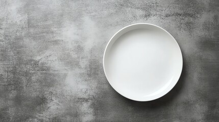 An empty white plate on a gray background.