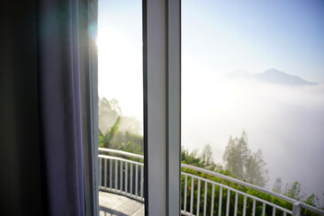 Fototapeta premium Bedroom morning view direct to the mountains cover with fog. Mount Batur, Kintamani, Bali, Indonesia.