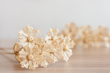 Flowers are made of straw on a white background. Straw weaving. Small depth of field.